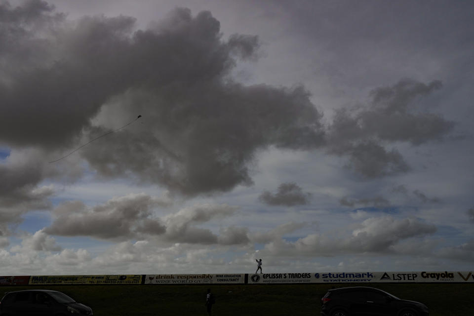 A boy flies a kite on the seawall in Georgetown, Guyana, Saturday, April 15, 2023. Few places are as vulnerable to climate change as Guyana, where most of the population lives below sea level on a coastline that relies on a nearly 300-mile seawall built centuries ago. (AP Photo/Matias Delacroix)