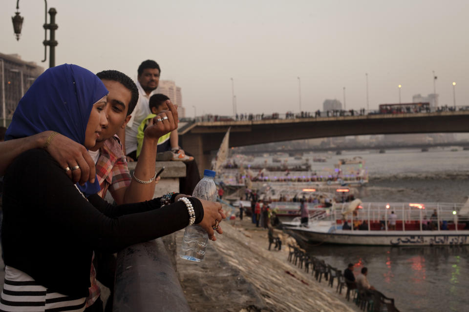 FILE - In this Monday, May 6, 2013 file photo, an Egyptian couple shares a moment as they overlook the Nile River as the country marks Sham el-Nessim, or “smelling the breeze,” in Cairo, Egypt. Women activists say they won a major step forward with Egypt’s new constitution, which enshrined greater rights for women. But months after its passage, they’re worrying whether those rights will be implemented or will turn out to be merely ink on paper. Men hold an overwhelming lock on decision-making and are doing little to bring equality, activists say, and the increasingly repressive political climate is stifling chances for reforms. (AP Photo/Maya Alleruzzo, File)
