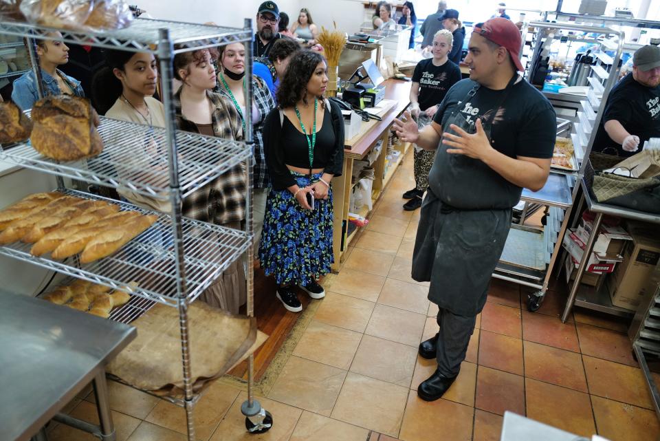 Brandon Roderick, owner of The Baker, speaks with Greater New Bedford Vocational Technical High School sophomore culinary arts students during their "tiny kitchen tour” visiting with entrepreneurs and food service professionals in downtown New Bedford talking about what it takes to be successful in “the business.