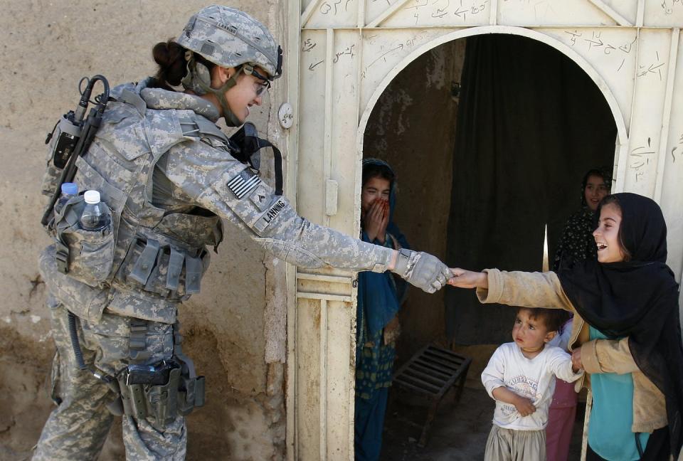 A US soldier meets Afghan girls during an information gathering operation in Kandahar City, 2010. Kirsty Wigglesworth/AP