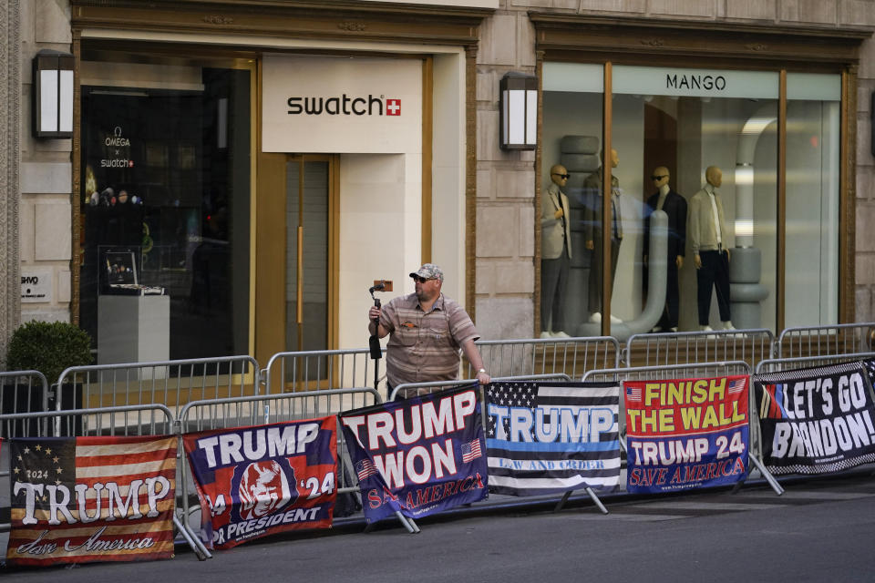 A supporter of former President Donald Trump makes a recording of himself near Trump Tower, Monday, April 3, 2023, in New York. Trump is planning to leave Florida for New York on Monday for his expected booking and arraignment the following day on charges arising from hush money payments during his 2016 campaign. (AP Photo/Bryan Woolston)