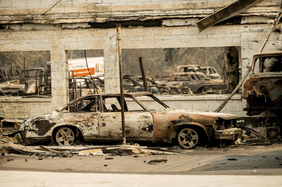 Scorched vehicles rest at an auto shop destroyed by the Almeda Fire in Talent, Ore., on Wednesday, Sept. 16, 2020. (AP Photo/Noah Berger)