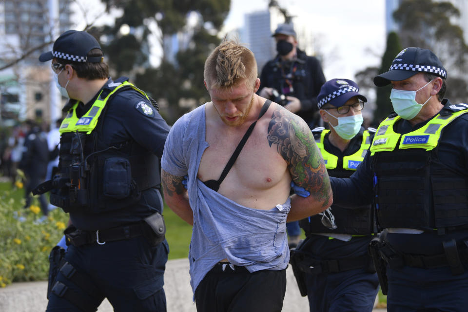 Police arrest a man as people gather at a so-called "Freedom Day" protest in Melbourne, Saturday, Sept. 5, 2020. Police in Australia's hardest-hit Victoria state are urging people to stay away from rallies protesting the lockdown in Melbourne. (James Ross/AAP Image via AP)