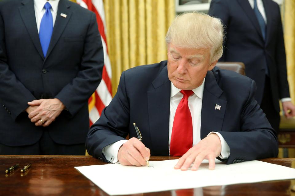 File photo of then-President Donald Trump signing an executive order.