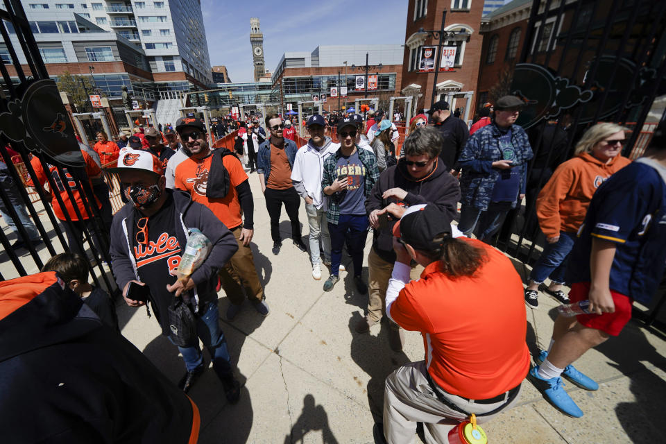 Spectators walk through the gates prior to a baseball game between the Baltimore Orioles and the Milwaukee Brewers on April 11. (AP Photo/Julio Cortez)