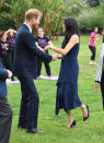 <p>With the help of her hubby Harry, Meghan took to the grass in a Dion Lee navy blue dress costing $1290 and her Manolo Blahnik BB pumps in navy suede. Photo: Getty </p>