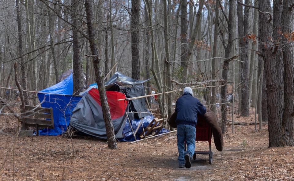 A homeless man pushes a shopping cart containing a donated matttress towards his tent. Homeless camp behind the Shop Rite in Neptune which is a concern to Neptune Township offiicials. 3/15/23