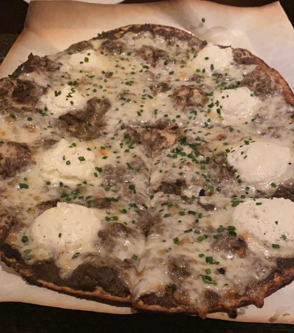 A close-up of a pizza with circles of mozzarella.