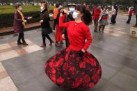 Residents wear masks as they dance at a park in Wuhan in central China's Hubei Province on Saturday, Jan. 23, 2021. A year after it was locked down to contain the spread of coronavirus, the central Chinese city of Wuhan has largely returned to normal, even as China continues to battle outbreaks elsewhere in the country. (AP Photo/Ng Han Guan)