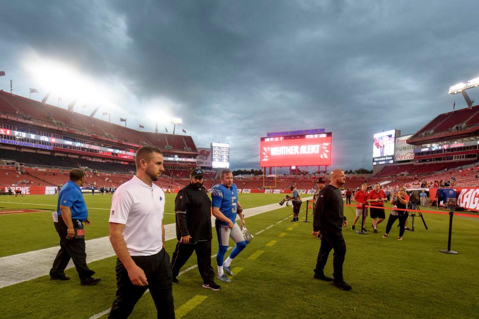 Lions coach Matt Patricia, center, and kicker Matt Prater exit the field due to a weather alert prior to the game against the Tampa Bay Buccaneers at Raymond James Stadium on Aug. 24, 2018.