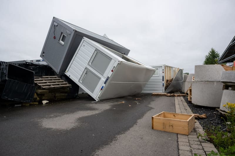 Containers lie overturned in the yard of a company that manufactures system and modular containers after a heavy storm in Telgte. Guido Kirchner/dpa