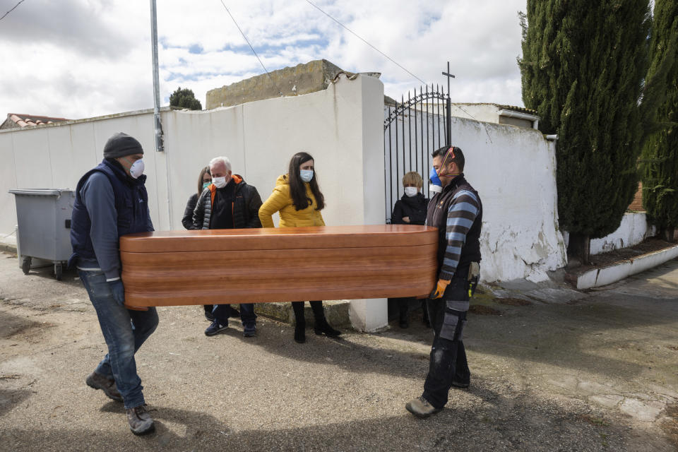 Undertakers carry the coffin of Rosalia Mascaraque, 86, during the coronavirus outbreak in Zarza de Tajo, central Spain, Wednesday, April 1, 2020. Intensive care units are particularly crucial in a pandemic in which tens of thousands of patients descend into acute respiratory distress. The new coronavirus causes mild or moderate symptoms for most people, but for some, especially older adults and people with existing health problems, it can cause more severe illness or death. (AP Photo/Bernat Armangue)