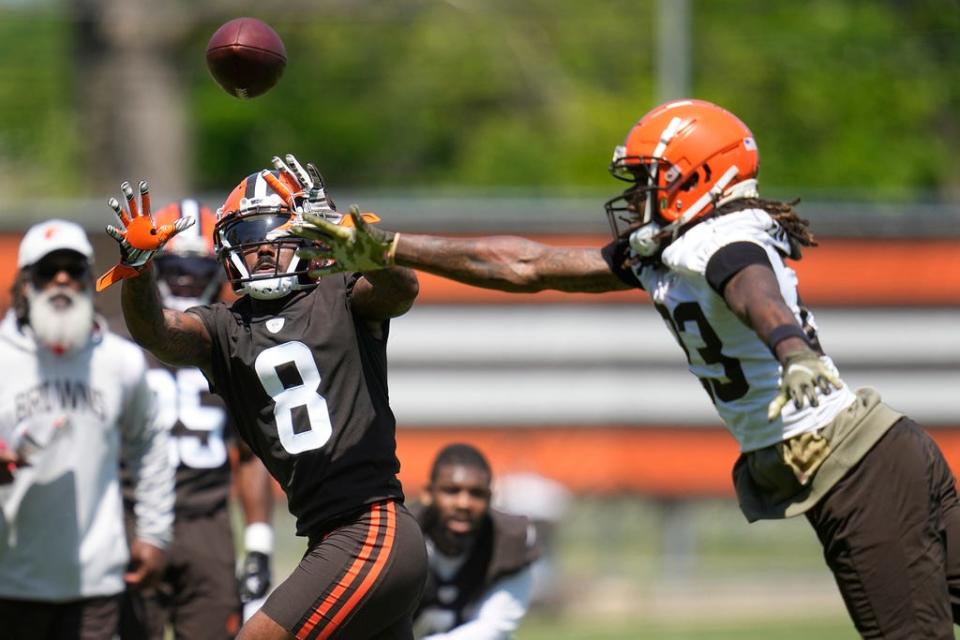 Cleveland Browns wide receiver Elijah Moore (8) reaches for a pass in front of cornerback Martin Emerson Jr., right, during practice Wednesday in Berea.