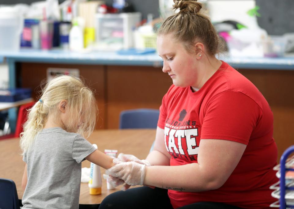 Assistant teacher Moriah Ware applies sunscreen to the one of the children at Community Child Care Center on Monday, July 13, 2020, in Kimberly.