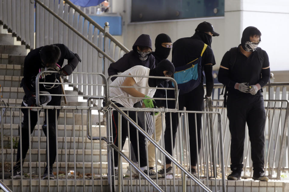 Protesters barricade a bridge near the Hong Kong Polytechnic University in Hong Kong, Saturday, Nov. 16, 2019. Rebellious students and anti-government protesters abandoned their occupation of at least one major Hong Kong university after a near weeklong siege by police, but some other schools remained under control of demonstrators on Saturday. (AP Photo/Achmad Ibrahim)