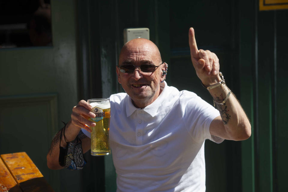 <p>A man holds up his pint in a beer garden in Belfast. Shops and outdoor hospitality venues are reopening across Northern Ireland where lockdown restrictions have begun to gradually ease. Picture date: Friday April 30, 2021.</p>
