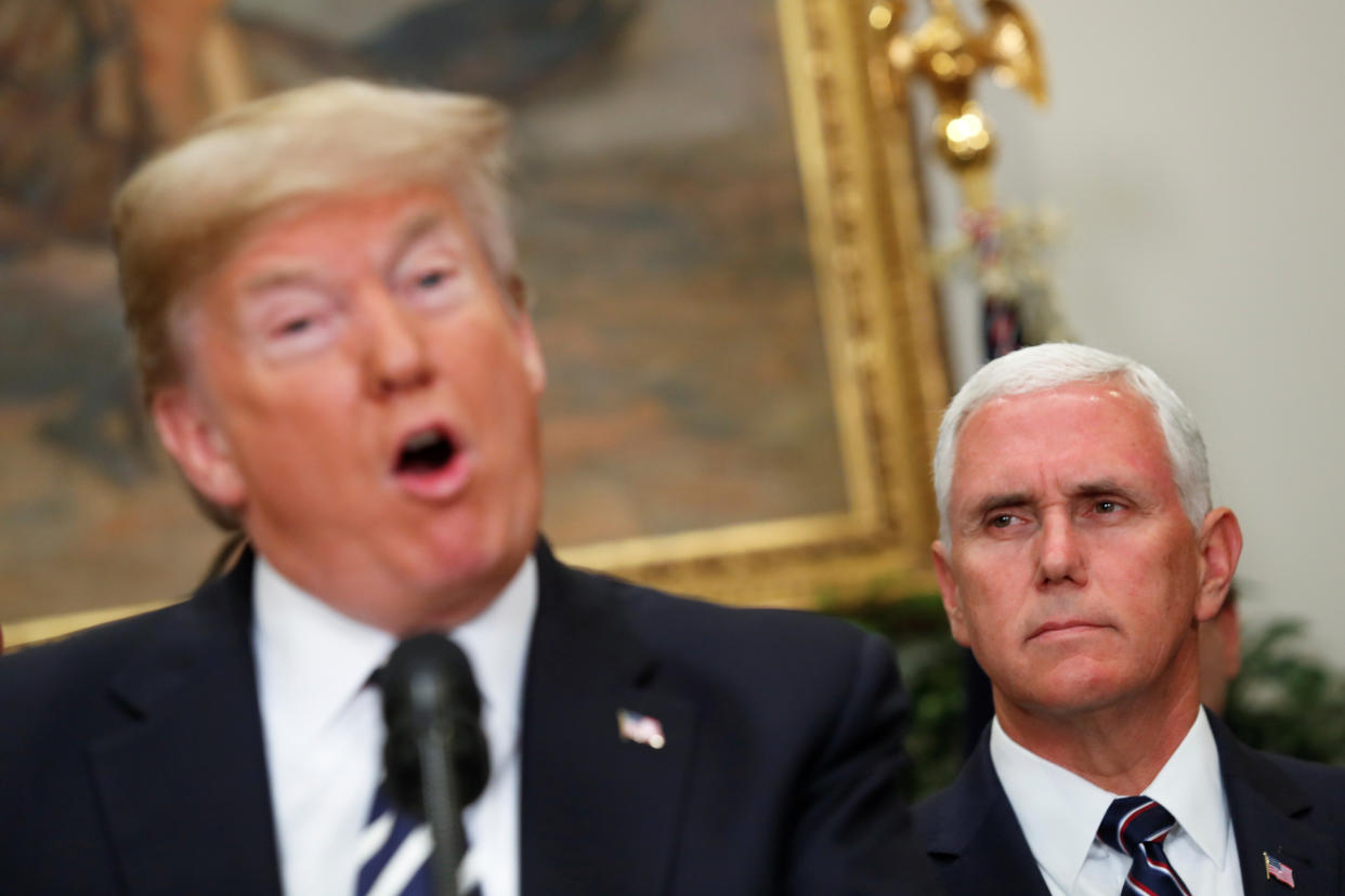 Vice President Mike Pence listens grimly as President Donald Trump floats an idea at the microphone.