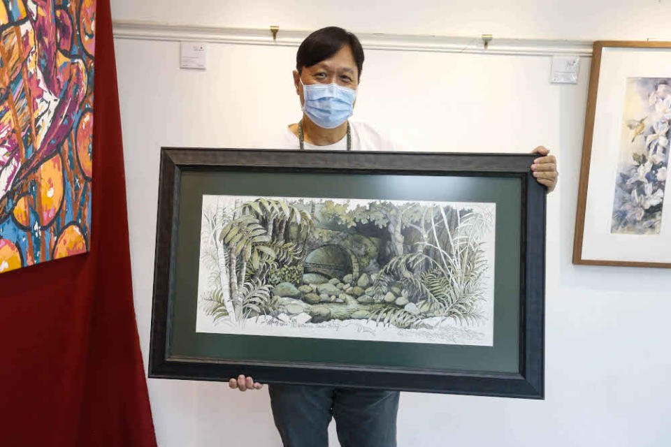 Lee Eng Beng shows his painting during an interview regarding his work being previewed here at The Art Gallery, Pulau Tikus October 15, 2021.