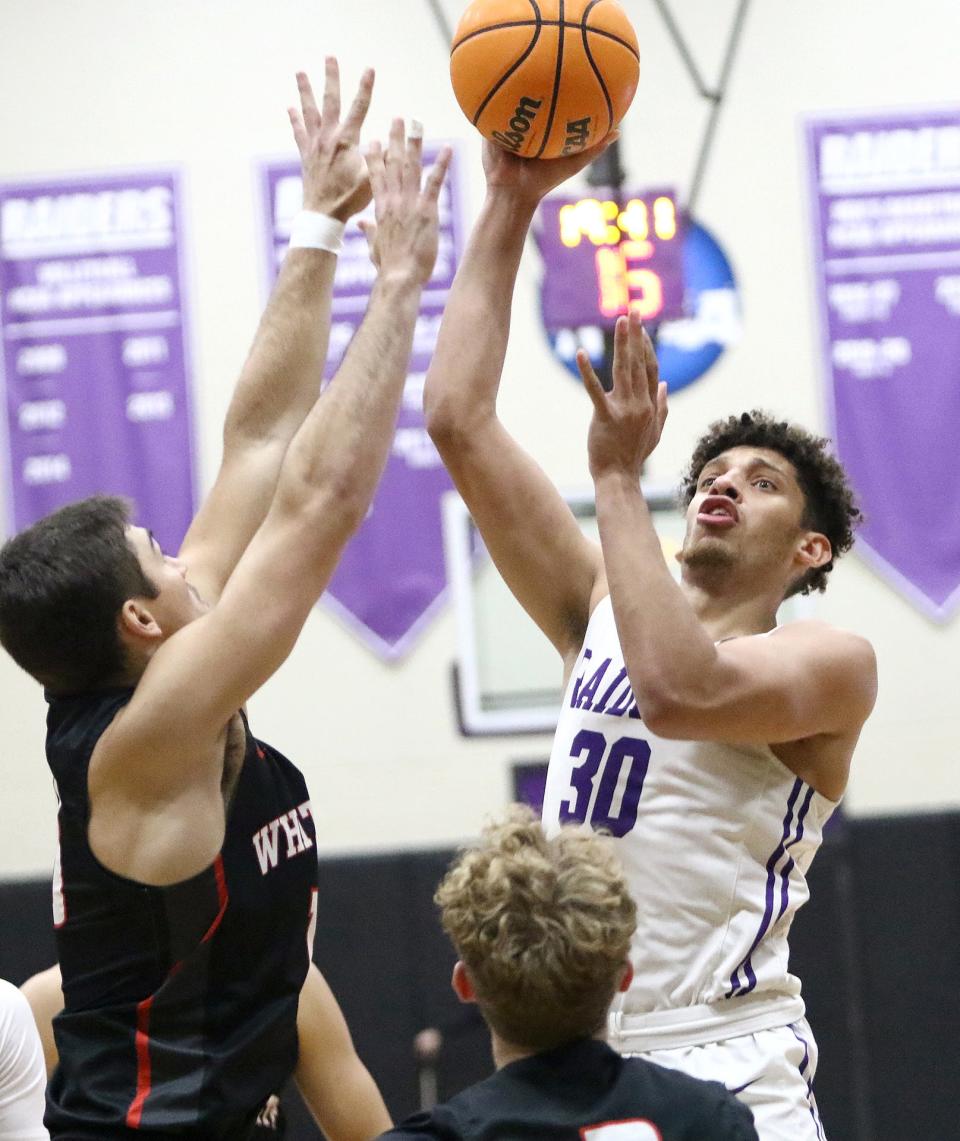 Mount Union's Braedon Poole puts up a shot over Whitworth's Michael Smith during the season opener Friday, November 11, 2022.