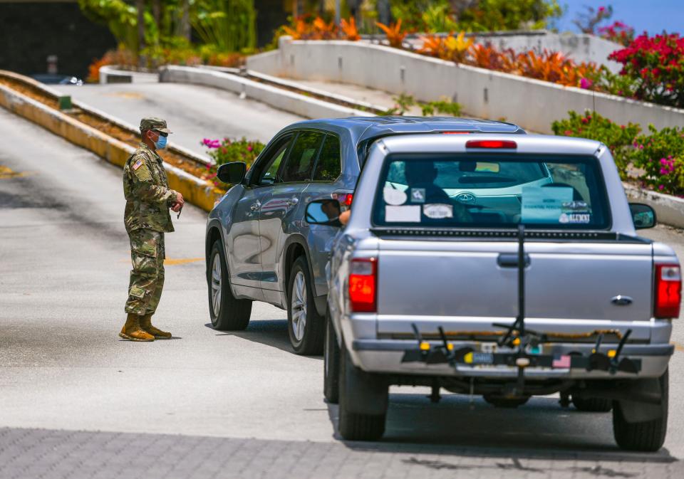 Drivers are stopped by a Guam National Guard soldier at a security checkpoint posted at the driveway entrance to the Pacific Star Resort & Spa in Tumon on Thursday, April 9, 2020. Hotels on island that normally cater to the island's tourism industry, were used to isolate some of the 5,000 military personnel who serve aboard the U.S.S. Theodore Roosevelt.