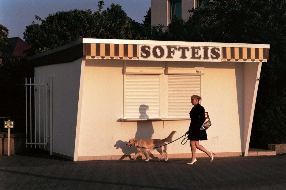 Early in the morning, a woman walks her dog in the still deserted tourist district of a coastal town in Warnemunde (Georg Kussmann/MACK)