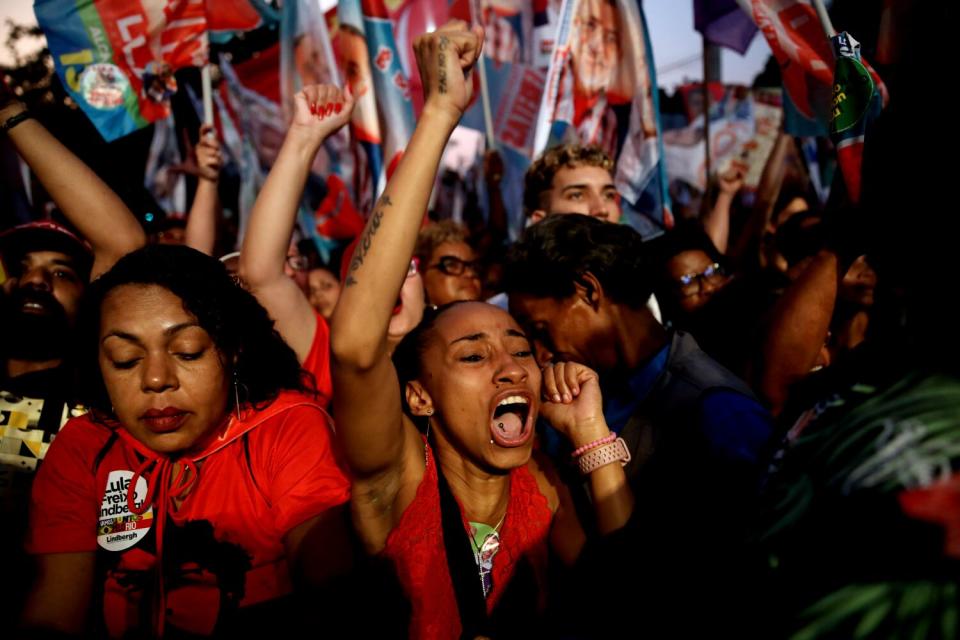 People raise their arms and shout.