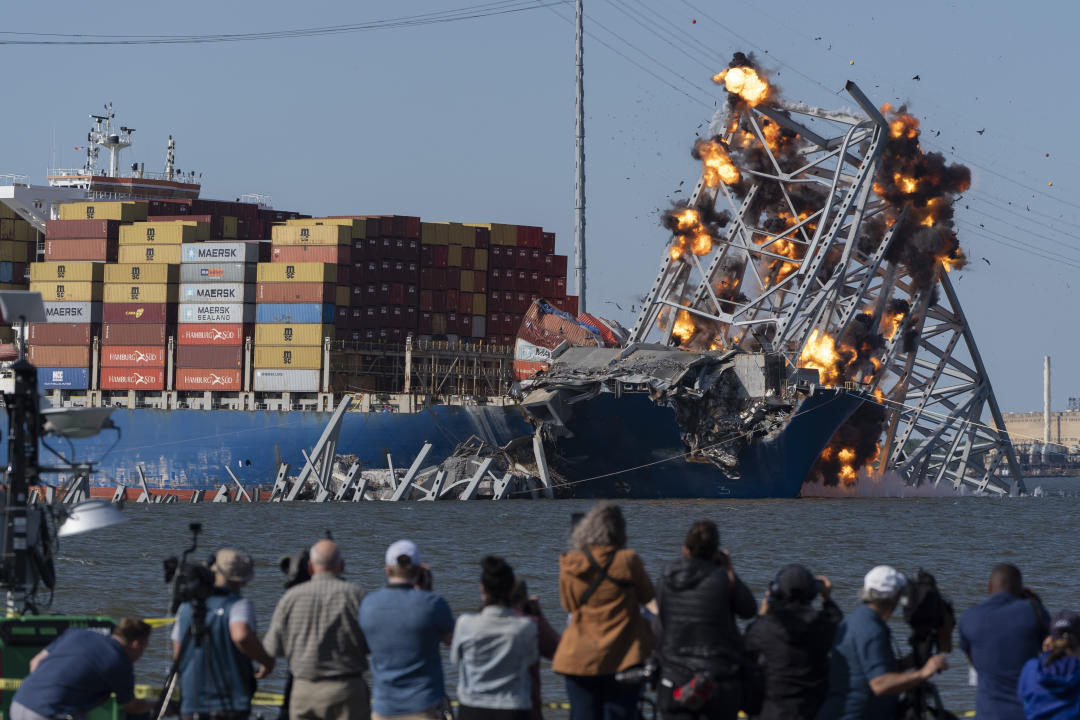 Explosive charges are detonated to bring down sections of the collapsed Francis Scott Key Bridge resting on the container ship Dali on Monday, May 13, 2024, in Baltimore. (AP Photo/Mark Schiefelbein)