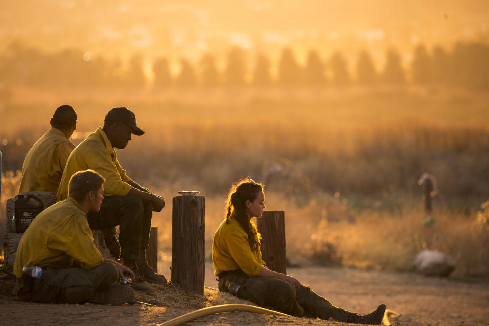 Firefighters rest during a wildfire in Yucaipa, Calif., Saturday, Sept. 5, 2020. Firefighters trying to contain the massive wildfires in Oregon, California and Washington state are constantly on the verge of exhaustion as they try to save suburban houses, including some in their own neighborhoods. (AP Photo/Ringo H.W. Chiu)