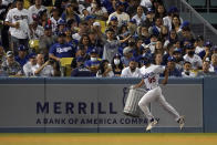 A ball boy removes an inflatable trash can from the field during the seventh inning of a baseball game between the Los Angeles Dodgers and the Houston Astros on Tuesday, Aug. 3, 2021, in Los Angeles. (AP Photo/Marcio Jose Sanchez)