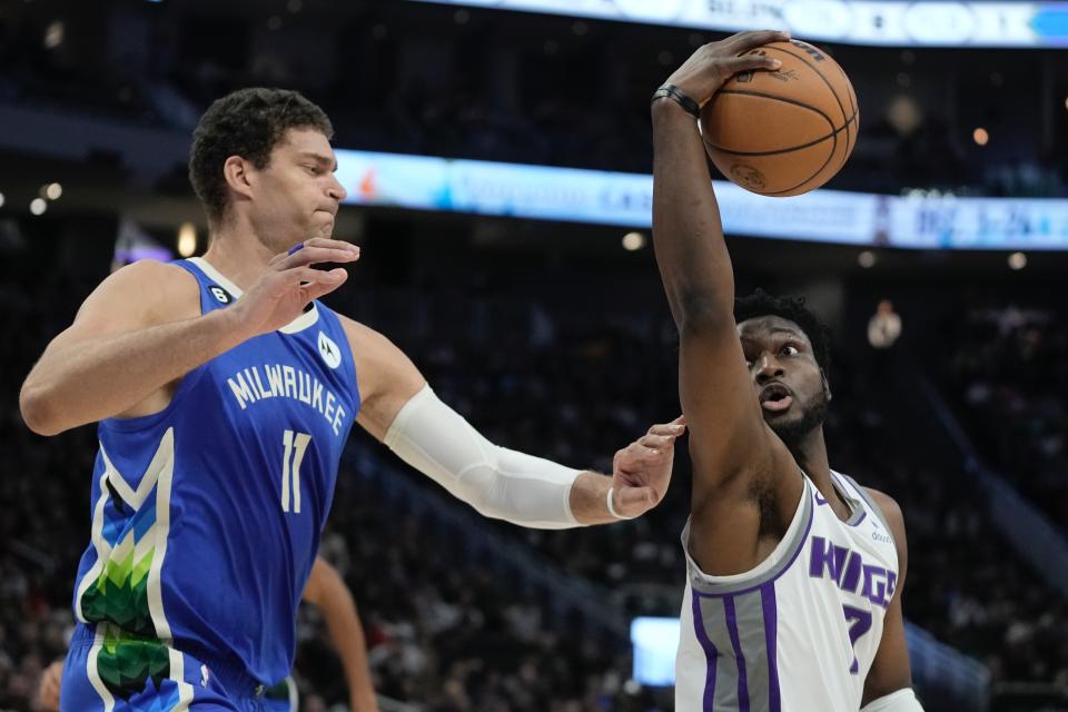 Sacramento Kings' Chimezie Metu looks to shoot past Milwaukee Bucks' Brook Lopez during the first half of an NBA basketball game Wednesday, Dec. 7, 2022, in Milwaukee. (AP Photo/Morry Gash)