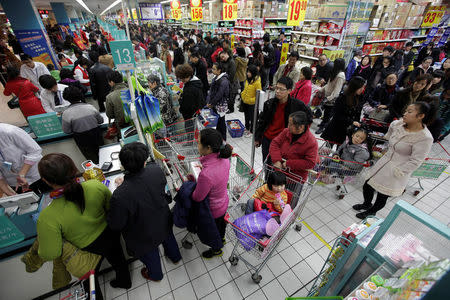 FILE PHOTO: Customers queue to pay as they shop at a Carrefour supermarket in Wuhan, Hubei province December 3, 2011. REUTERS/Stringer/File Photo