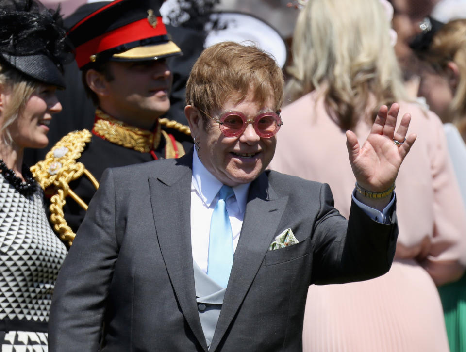 Sir Elton John waves as he leaves St George's Chapel in Windsor Castle following the wedding of Prince Harry and Meghan Markle.