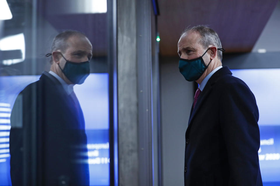 Ireland's Prime Minister Micheal Martin leaves at the end of an EU summit in Brussels, Friday, Dec. 11, 2020. European Union leaders have reached a hard-fought deal to cut the bloc's greenhouse gas emissions by at least 55 percent by the end of the decade compared with 1990 levels, avoiding a hugely embarrassing deadlock ahead of a U.N. climate meeting this weekend. (AP Photo/Francisco Seco, Pool)