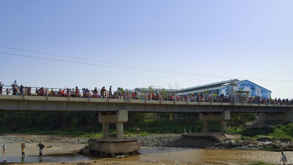 People crossing a bridge at the border between Haiti and the Dominican Republic. (Hispaniola Productions)