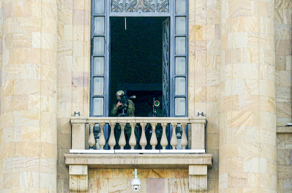 A security agent points a sniper rifle from a window of the Parliament building as opposition demonstrators rally to pressure Armenian Prime Minister Nikol Pashinyan to resign in Yerevan, Armenia, Wednesday, March 3, 2021. Armenia’s prime minister has scored a point in his spat with the top military brass, advancing his motion to fire the country’s top military officer. A political crisis sparked by Armenia’s defeat in the conflict with Azerbaijan over the Nagorno-Karabakh region escalated last week when the military’s General Staff demanded the resignation of Prime Minister Nikol Pashinyan following his move to dismiss a top general. (Hrant Khachatryan/PAN Photo via AP)