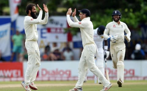 England's Moeen Ali (L) celebrates with teammates after he dismissed Sri Lanka's Angelo Mathews during the fourth day of the opening Test match between Sri Lanka and England at the Galle International Cricket Stadium in Galle - Credit: ISHARA S. KODIKARA / AFP