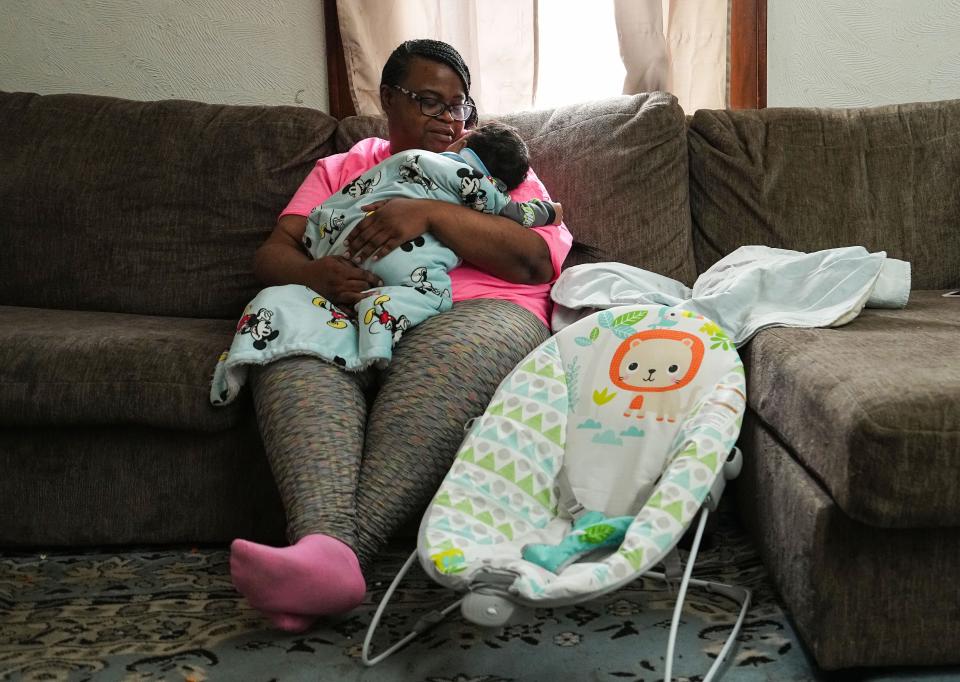 "This is my new muse," Angela Hughley said while holding her grandson Keion Adams. Hughley, 42, was shot in the chest during last April's mass shooting at a FedEx center on the southwest side of Indianapolis.  Hughley holds her grandson on Saturday, April 9, 2022, at her home in Indianapolis.