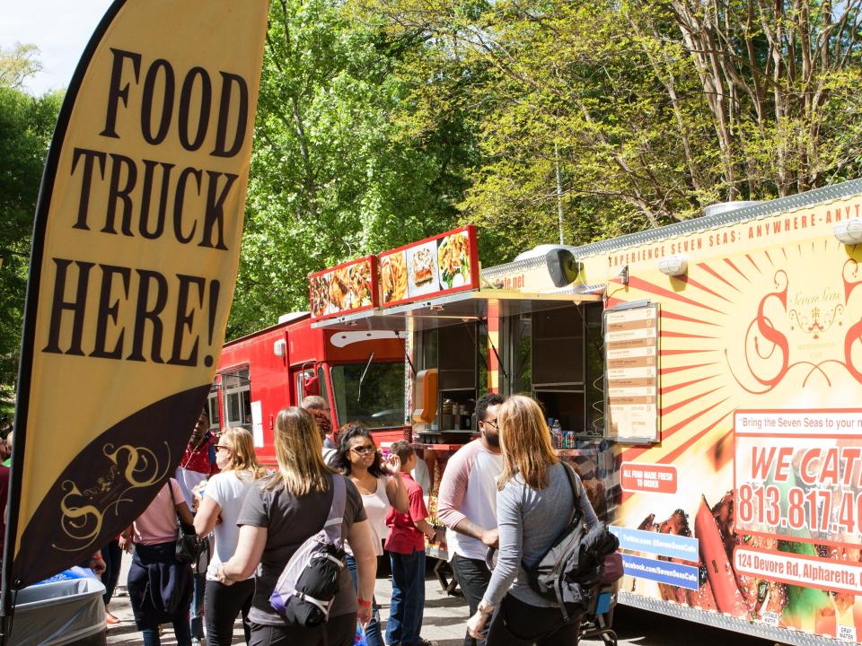 shot of a sign that read "food trucks here" in front of a food truck in atlanta georgia