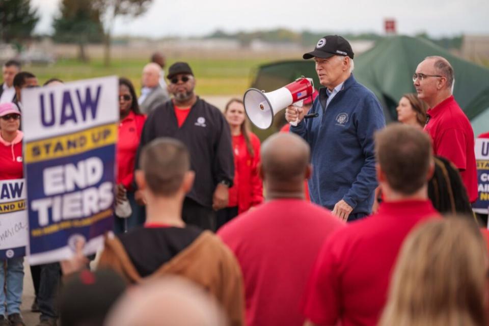 President Joe Biden speaking into a megaphone to a crowd of workers