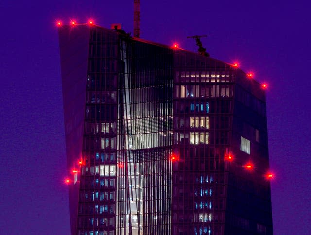 Red lights shine on top of the European Central Bank in Frankfurt (Michael Probst/AP)