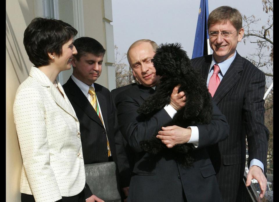 Putin cuddles a Hungarian Puli dog as the dog's owners, then-Hungarian Prime Minister Ferenc Gyurcsany&nbsp;and&nbsp;his wife Klara Dobrev, look on, in Budapest, Hungary, on March 1, 2006.