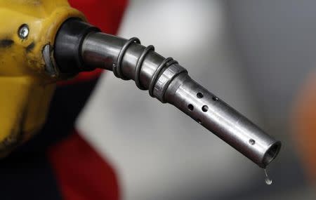 An employee holds a gas pump to refill a car at a petrol station in central Seoul April 6, 2011. REUTERS/Lee Jae-Won