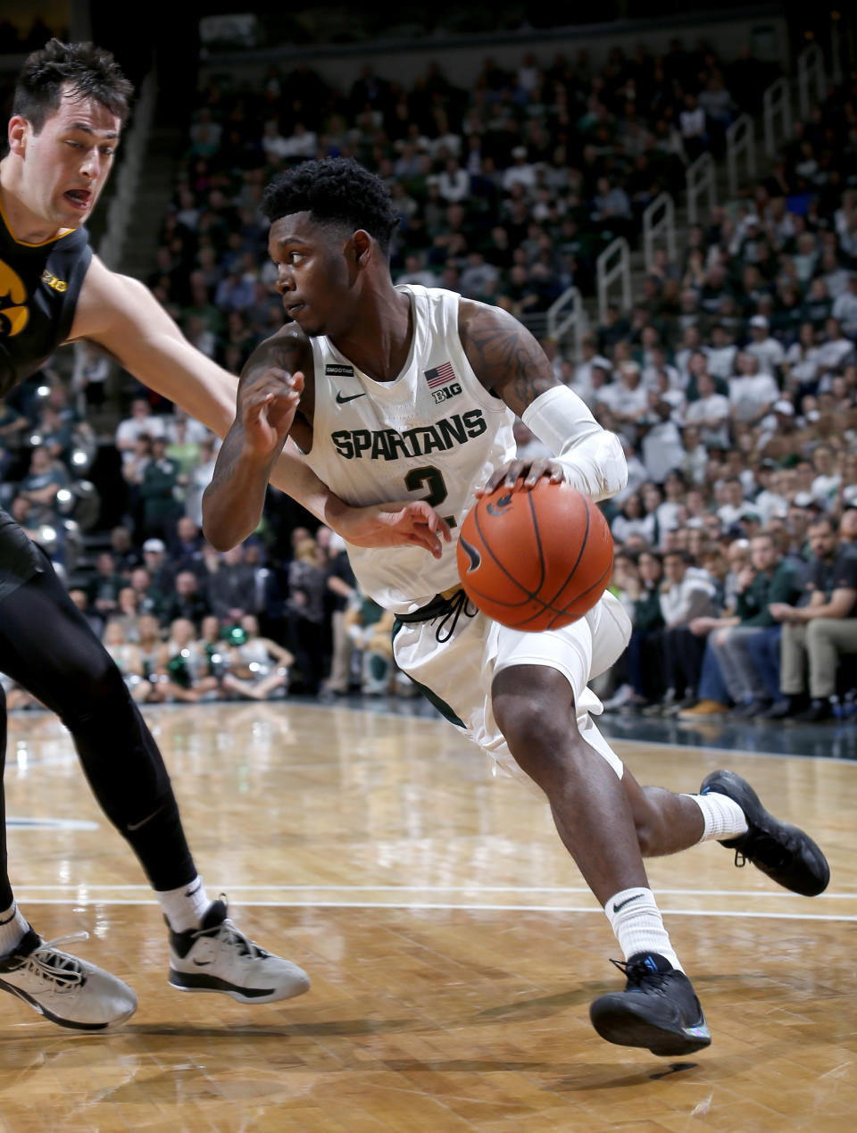 Michigan State's Rocket Watts, right, drives against Iowa's Ryan Kriener during the second half of an NCAA college basketball game, Tuesday, Feb. 25, 2020, in East Lansing, Mich. Michigan State won 78-70. (AP Photo/Al Goldis)