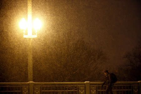 A man walks in the snow after a winter storm arrived in Washington January 22, 2016. REUTERS/Carlos Barria