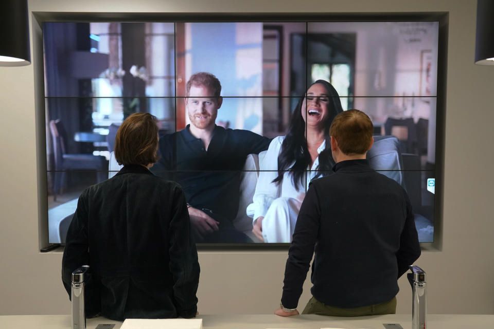 Office workers in London, watch the Duke and Duchess of Sussex's controversial documentary being aired on Netflix Thursday, Dec. 8, 2022. Britain’s monarchy is bracing for more bombshells to be lobbed over the palace gates as Netflix releases the first three episodes of a new series. The show “Harry & Meghan” promises to tell the “full truth” about Prince Harry and his wife Meghan’s estrangement from the royal family. The series debuted Thursday. (Jonathan Brady/PA via AP)