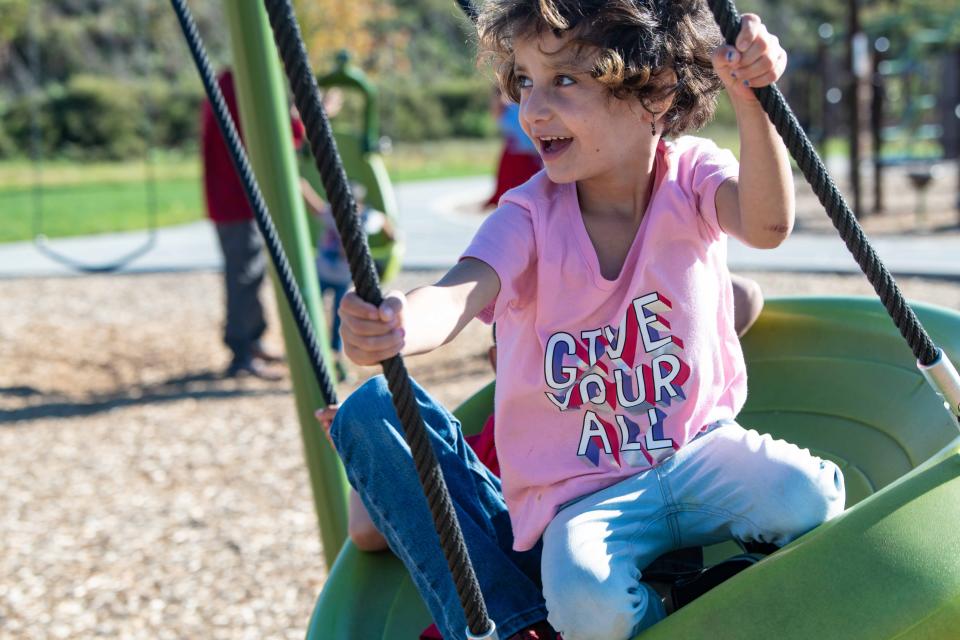 Zainab Azizyar, 5, plays in a park in Mechanicsburg, Pennsylvania, while waiting to move into the house found for her and her family by Catholic Charities.