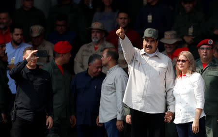 Venezuela's President Nicolas Maduro, next to his wife Cilia Flores, takes part in a ceremony to mark the 17th anniversary of the return to power of Venezuela's late President Hugo Chavez after a coup attempt and the National Militia Day in Caracas, Venezuela April 13, 2019. REUTERS/Carlos Garcia Rawlins