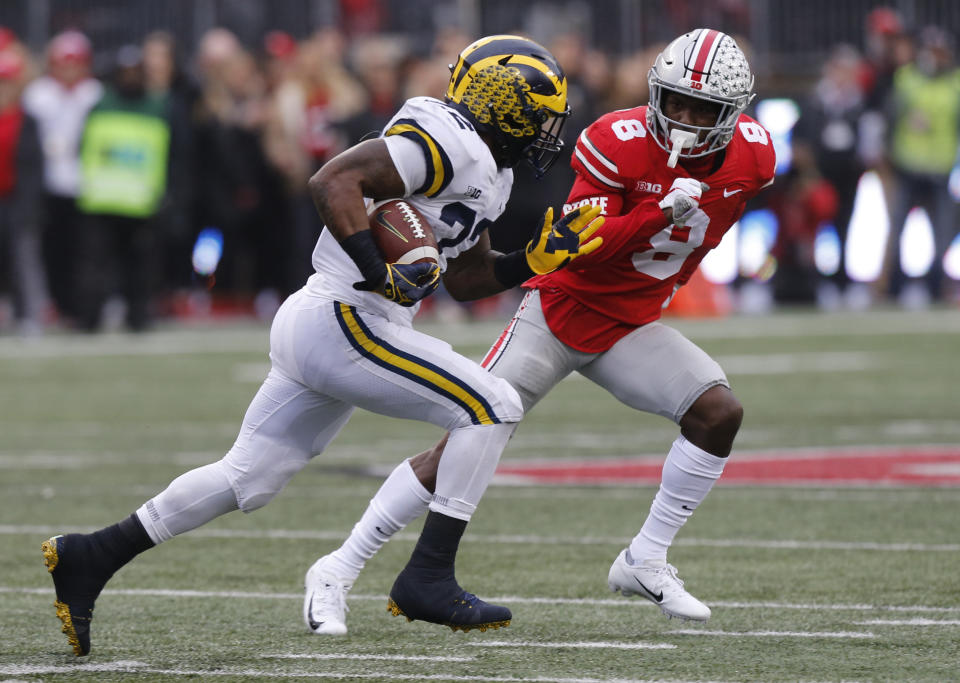 Michigan running back Karan Higdon, right, turns up field against Ohio State defensive back Kendall Sheffield during the first half of an NCAA college football game Saturday, Nov. 24, 2018, in Columbus, Ohio. (AP Photo/Jay LaPrete)