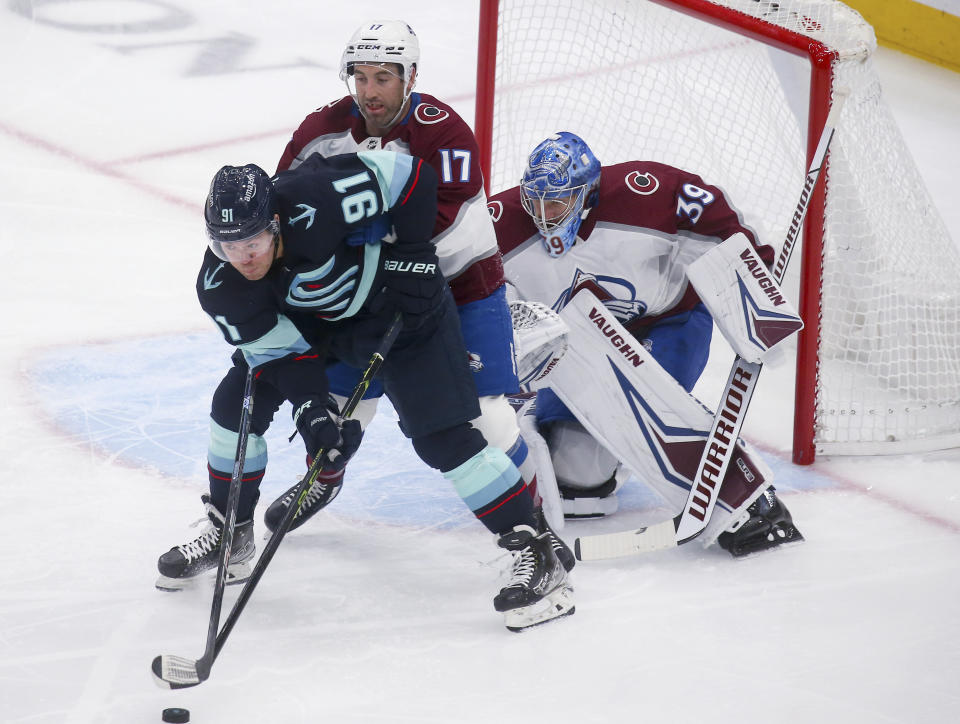 Seattle Kraken right wing Daniel Sprong (91) tries to field the puck in front of Colorado Avalanche's Brad Hunt (17) and Pavel Francouz (39) during the first period of an NHL hockey game Saturday, Jan. 21, 2023, in Seattle. (AP Photo/Lindsey Wasson)