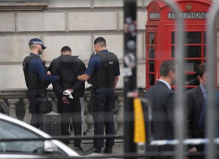 A man is held by police in Westminster after an arrest was made on Whitehall in central London, Britain, April 27, 2017. REUTERS/Toby Melville